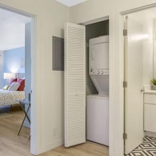 A compact laundry area featuring a stacked washer and dryer, seamlessly integrated into the apartment's design.
