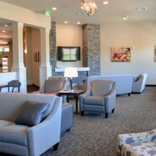A modern living room featuring comfortable sofas, a fireplace, and natural lighting.