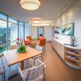 A modern living and dining area with large windows and contemporary furnishings.