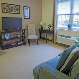 A cozy living room with a television, sofa, and decorative elements.