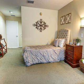 A cozy bedroom with stylish decor, featuring a bed with a tufted headboard and two nightstands.