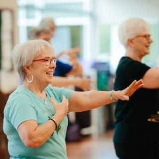 A group of elderly individuals participating in a fitness class indoors.