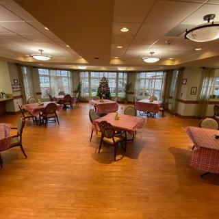 A cozy dining area with wooden floors and neatly arranged tables.