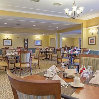 A spacious dining room with elegantly set tables and comfortable seating.