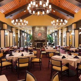 Elegant restaurant interior with chandeliers and neatly arranged tables.