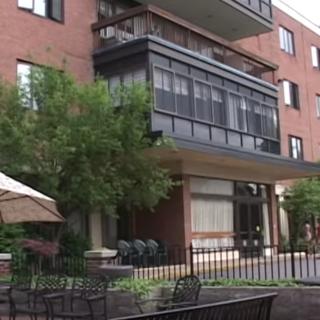 A multi-story apartment building with balconies and a patio area.