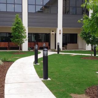 A modern building entrance with a curved walkway and outdoor landscaping.