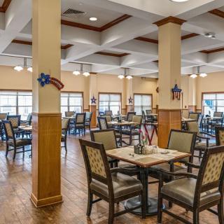 An empty dining room with neatly arranged tables and chairs, featuring decorative elements.