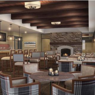 A cozy lounge area with a fireplace, featuring comfortable seating and wooden beam ceilings.