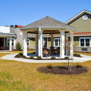 A well-maintained outdoor area featuring a gazebo surrounded by landscaped greenery.