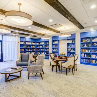 Modern library interior with comfortable seating and blue-accented bookshelves.