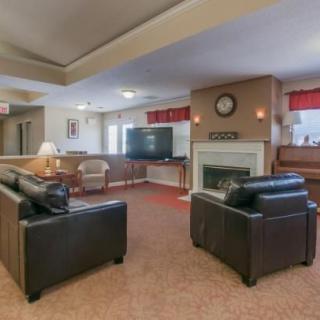 A cozy living room with comfortable sofas, a fireplace, and a television.