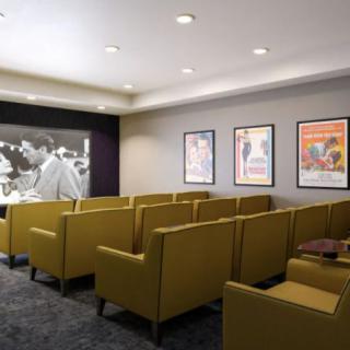 A cozy home theater setup with comfortable seating and classic movie posters on the walls.