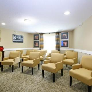 A small conference room with arranged chairs and framed pictures on the walls.
