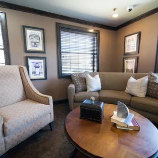 A cozy living room with tasteful decor, featuring a sofa, armchair, and coffee table.