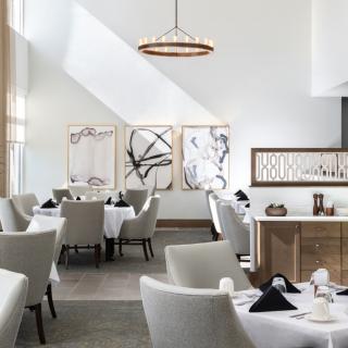 A modern restaurant dining area featuring elegant decor with contemporary artwork and stylish furnishings.