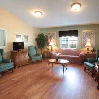 A cozy living room with comfortable seating, wooden floors, and warm lighting.