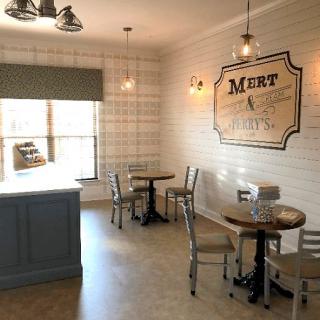 Cozy cafe interior with tables and chairs, featuring vintage-style signage.