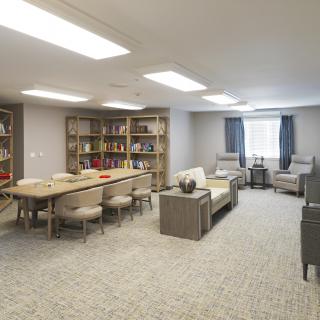 A cozy library room with bookshelves and comfortable seating.