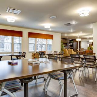 A bright and modern dining area featuring tables and chairs, perfect for communal gatherings.