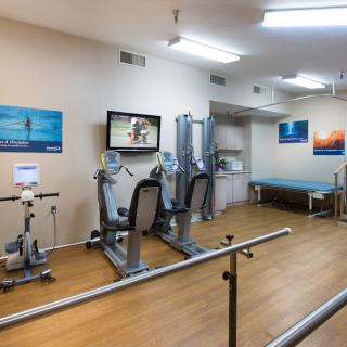 A well-equipped rehabilitation room with exercise and therapy equipment.