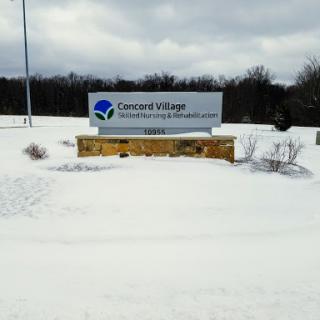 A snowy scene featuring the sign for Crowned Village, indicating a residential or community area.