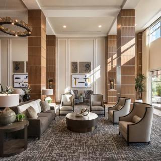 A luxurious and modern lobby with an inviting seating area, featuring large windows that allow natural light to illuminate the space.