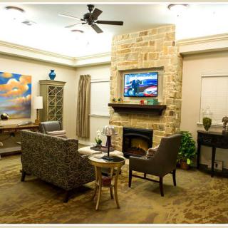 A modern living room with a stone fireplace, television, and stylish furniture.