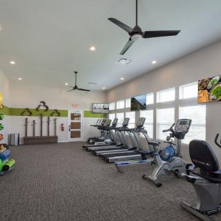 A modern gym with treadmills and various exercise equipment in a spacious, well-lit room.
