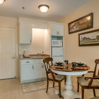 A cozy kitchen and dining area featuring a small round table with chairs, set in a compact apartment space.