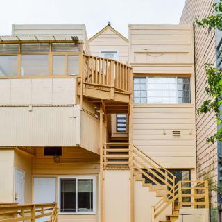 A view of wooden stairs and balconies on the exterior of an apartment building.