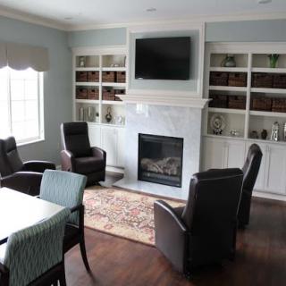 A cozy living room featuring a fireplace, comfortable seating, and an entertainment center.