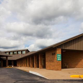 A brick building with a sloped roof under a cloudy sky.