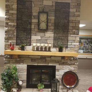 A cozy fireplace setup featuring a stone wall and decorative elements.