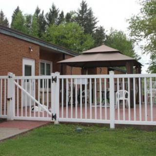 A backyard patio with a white fence and a gazebo.