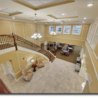 A spacious lobby area with a grand staircase, comfortable seating, and elegant lighting.