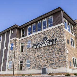 A modern stone facade building housing a college or school.