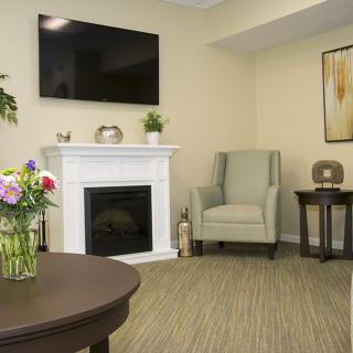A cozy living room with a fireplace, armchair, and modern decor.
