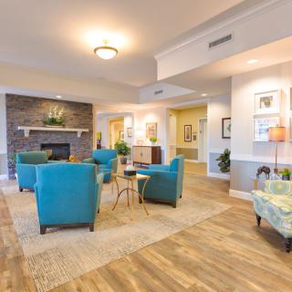 A modern living room featuring comfortable seating, a fireplace, and bright lighting.