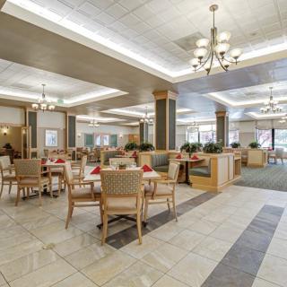 A spacious dining area with contemporary furnishings and elegant chandeliers.