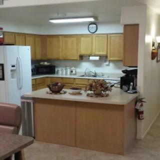 A modern kitchen with wooden cabinets and a central countertop featuring various appliances.