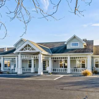 A charming residential building with a welcoming front porch and picturesque architecture.