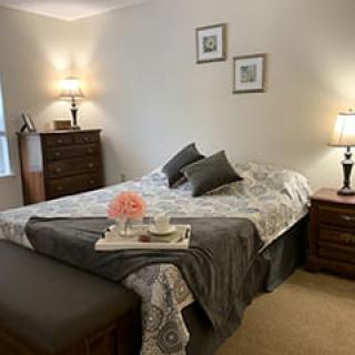 A cozy bedroom with a neatly made bed, bedside tables with lamps, and elegant decor.