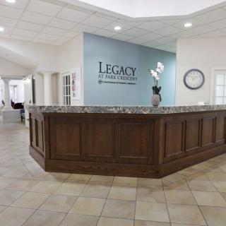 A modern office reception area with a wooden desk and tiled floor.