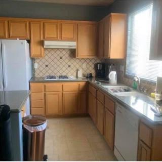 A modern kitchen with wooden cabinets and various appliances.