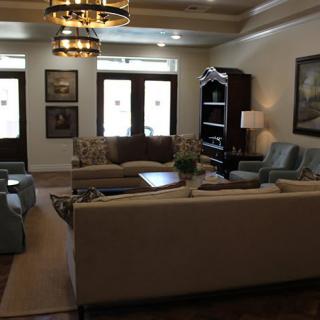 A cozy living room with comfortable sofas, elegant chandeliers, and stylish decor.