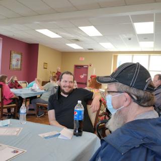 A relaxed social gathering in an indoor caf setting, where two individuals engage in conversation.