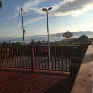 A scenic view from a deck overlooking the ocean on a sunny day.