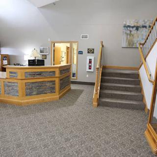 A welcoming reception area featuring a central desk and a staircase leading upwards.