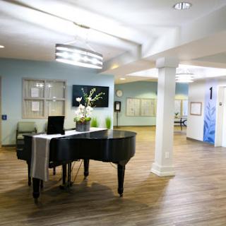 A modern lobby featuring a grand piano and bright decor, creating a welcoming atmosphere.